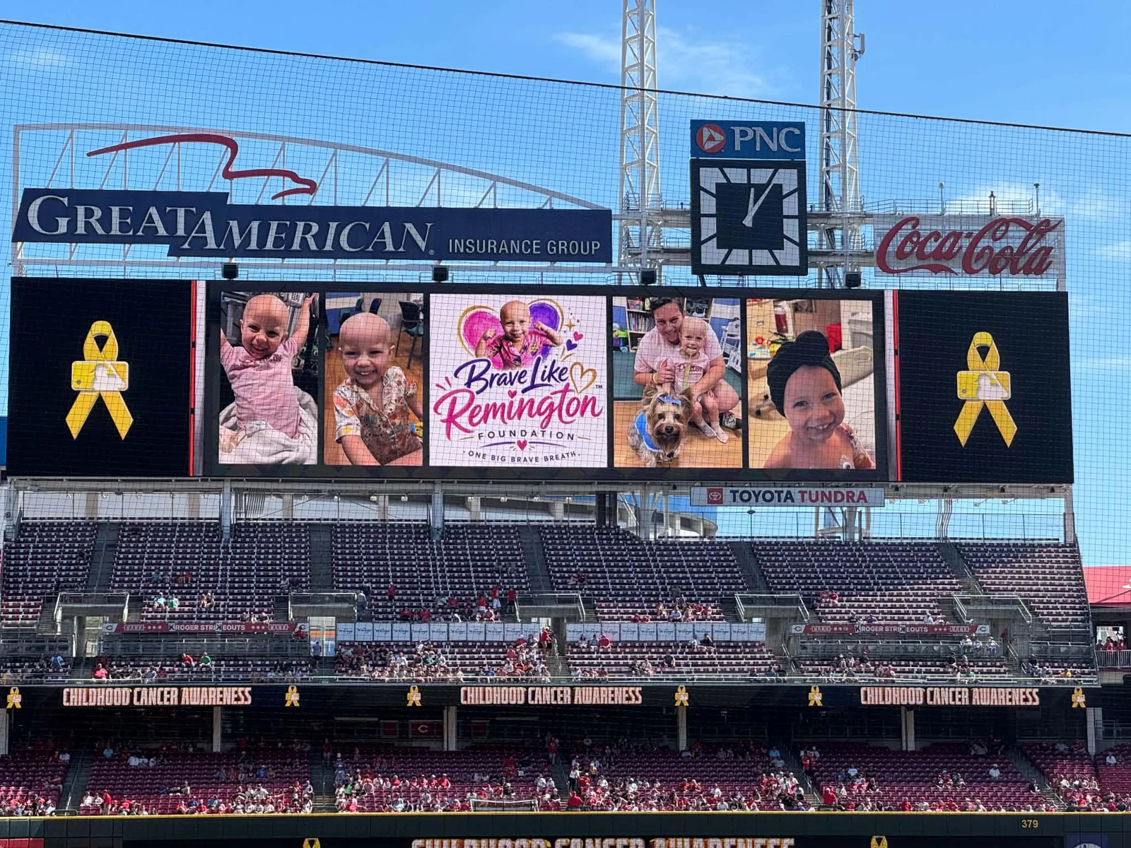 The Brave Like Remington Foundation logo and photos displayed across the main scoreboard at Great American Ball Park