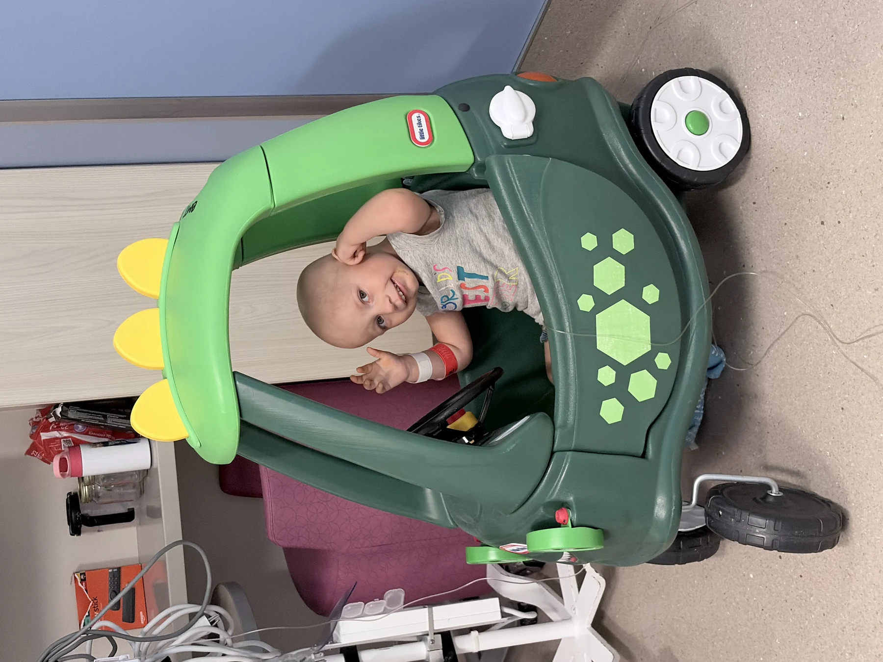 Remington playing in a toy car during a hospital stay